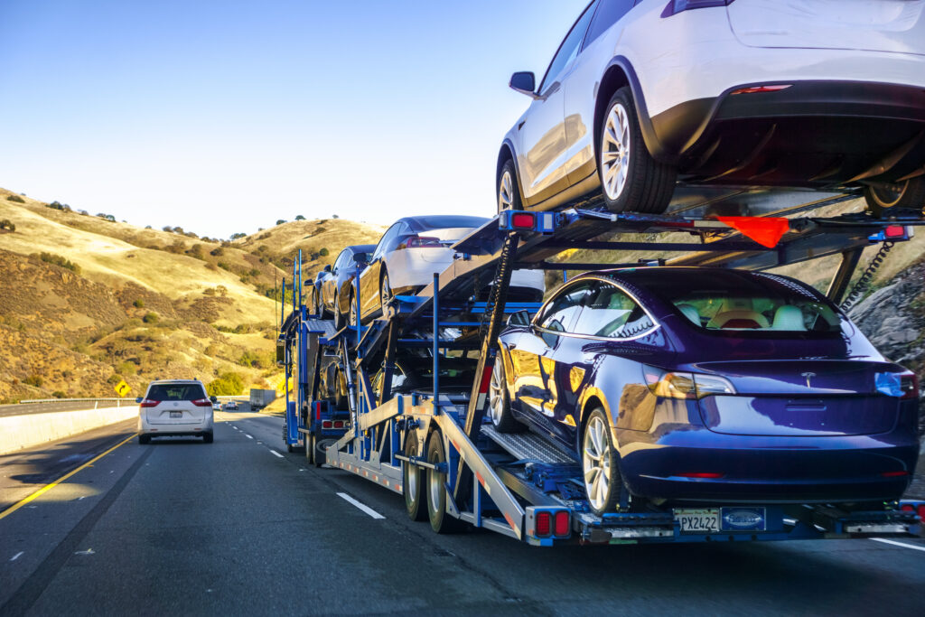 Snowbird vehicle transport from Aspen, CO with Autos On The Go Open car carrier transporting vehicles on a highway from Aspen, Colorado to popular snowbird destinations in Arizona, Florida, and California.